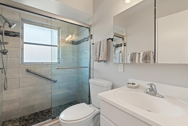 bathroom featuring vanity, an enclosed shower, and toilet