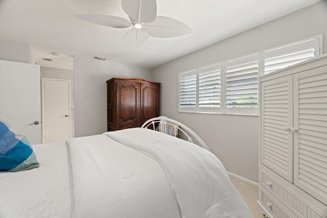 carpeted bedroom featuring a textured ceiling and ceiling fan