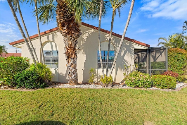 view of property exterior with a lanai and a yard