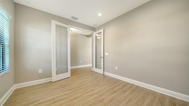 unfurnished bedroom featuring light wood-type flooring and french doors