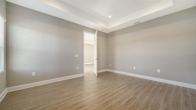 spare room with a raised ceiling