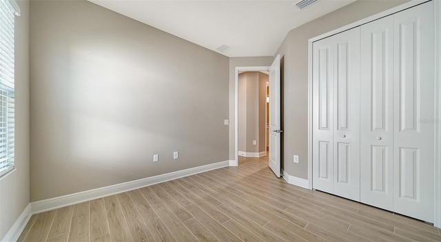 unfurnished bedroom featuring a closet and light hardwood / wood-style flooring