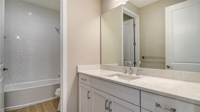 full bathroom with toilet, vanity, tiled shower / bath, and hardwood / wood-style flooring