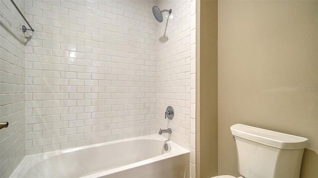 bathroom featuring toilet and tiled shower / bath