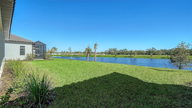 view of yard with a lanai and a water view