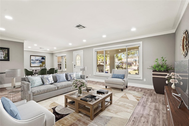 living room featuring crown molding and light hardwood / wood-style flooring