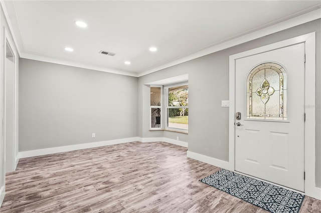 foyer entrance with hardwood / wood-style floors and crown molding