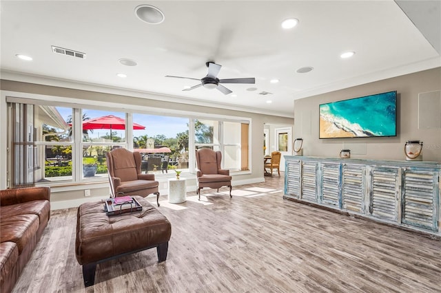 living room featuring hardwood / wood-style flooring, crown molding, and ceiling fan