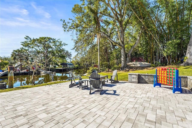 view of patio with a dock and a water view