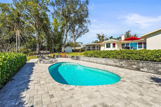 view of pool with a sunroom and a patio