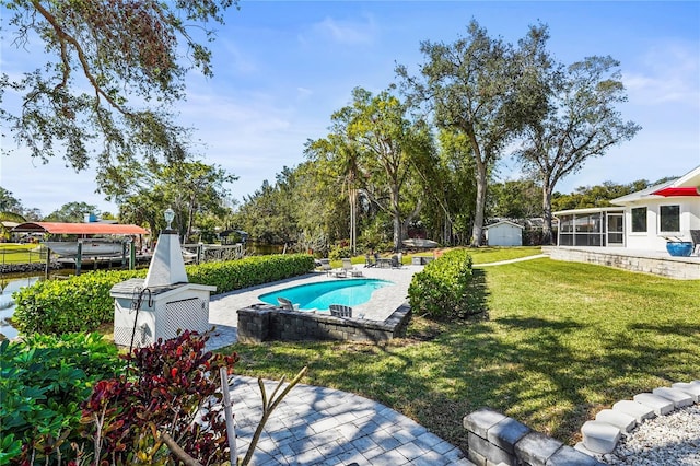 view of pool with a storage unit, a yard, a sunroom, and a patio area