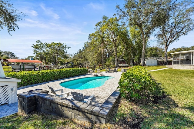 view of pool featuring a shed, a yard, and a patio