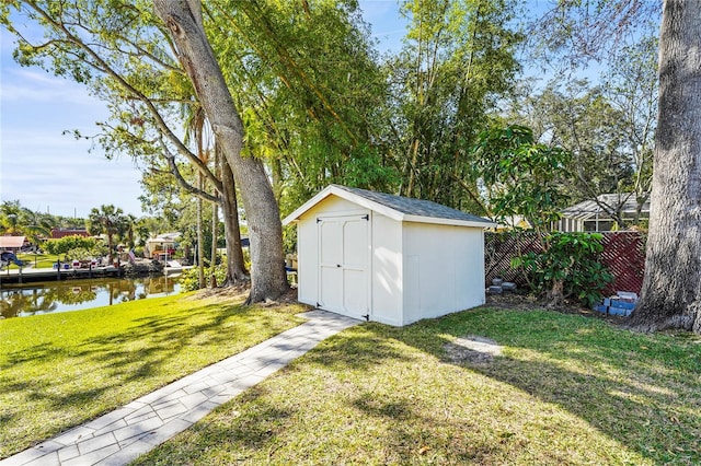 view of outbuilding with a water view and a yard