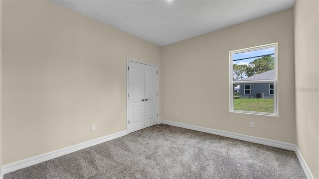 spare room featuring carpet floors and a textured ceiling