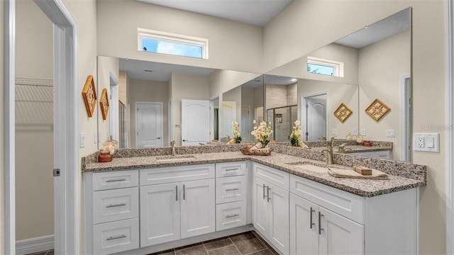 bathroom featuring a shower with door, vanity, and tile patterned flooring