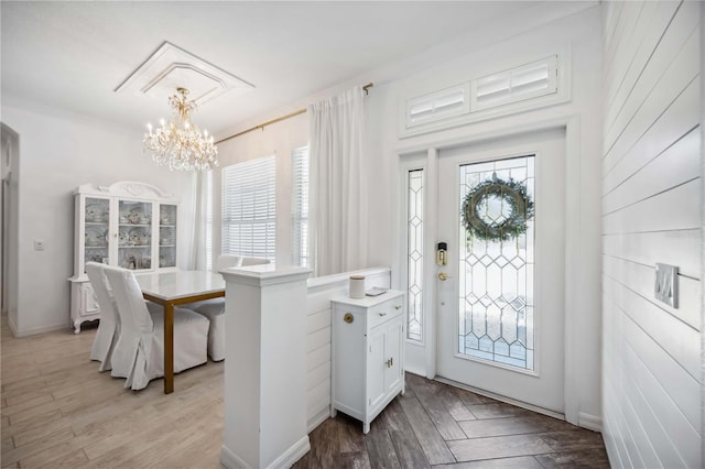 foyer with a wealth of natural light, light hardwood / wood-style floors, and a chandelier