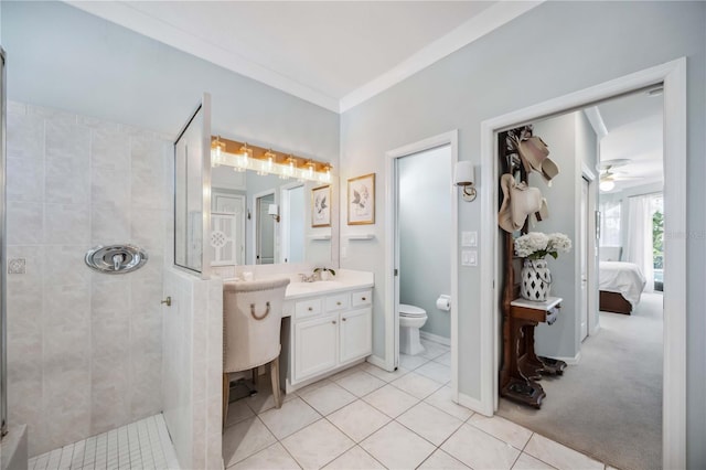 bathroom featuring tiled shower, tile patterned floors, toilet, vanity, and ornamental molding