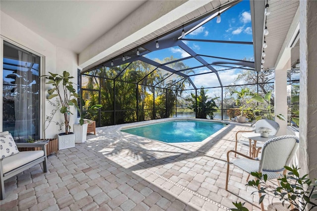 view of pool featuring a patio and glass enclosure