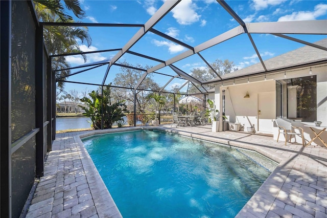 view of pool with a patio, a water view, and a lanai