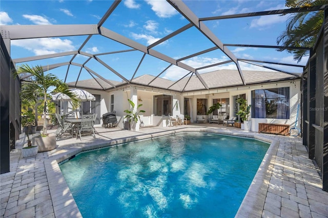 view of swimming pool featuring a lanai and a patio