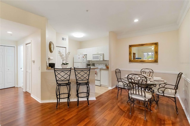 dining room featuring light hardwood / wood-style floors and ornamental molding