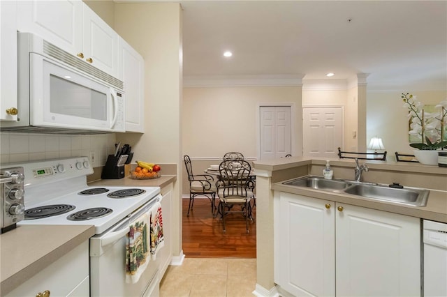 kitchen featuring crown molding, sink, white cabinets, light tile patterned floors, and white appliances