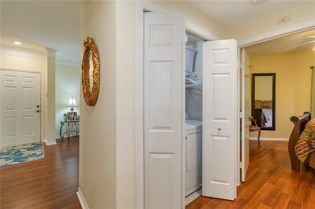 corridor with hardwood / wood-style flooring, washer / dryer, and crown molding