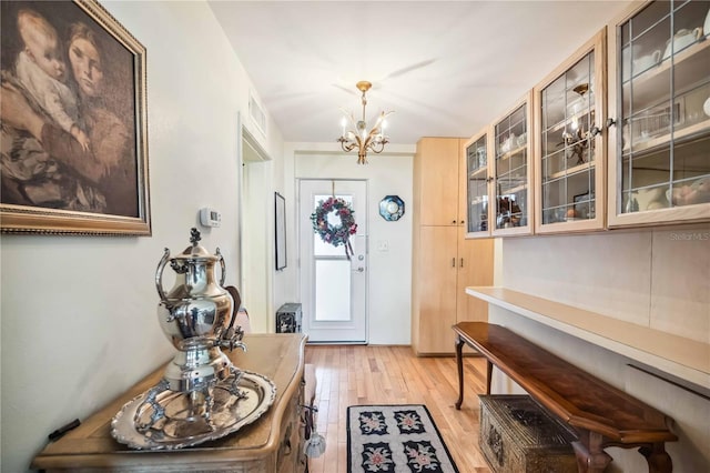 foyer featuring light hardwood / wood-style flooring and a notable chandelier