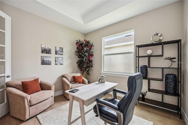 office area with a tray ceiling