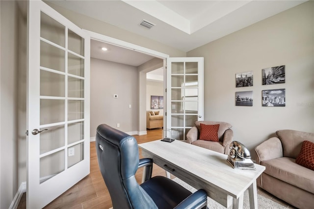 home office featuring french doors and light wood-type flooring