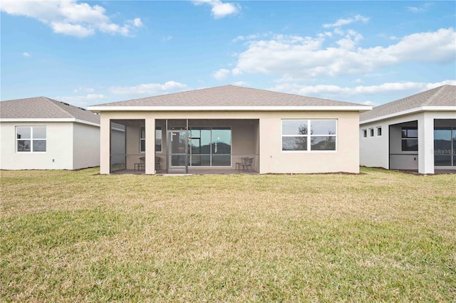 rear view of house with a sunroom and a lawn