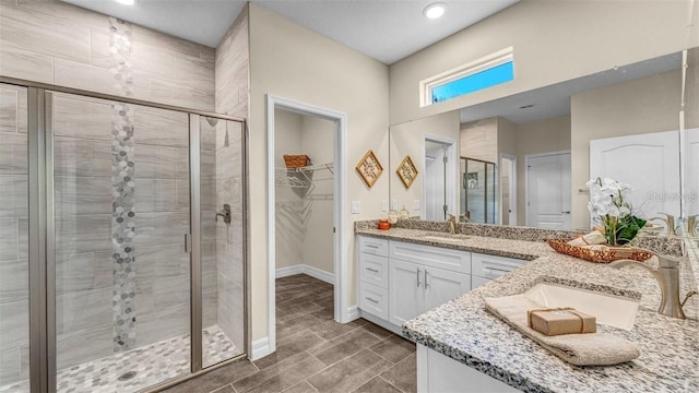 bathroom featuring vanity and a shower with door