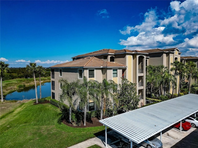 exterior space with a lawn, a carport, and a water view