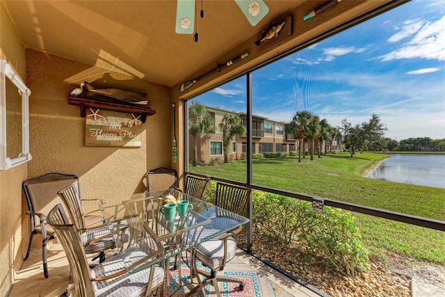 sunroom / solarium featuring a water view and ceiling fan