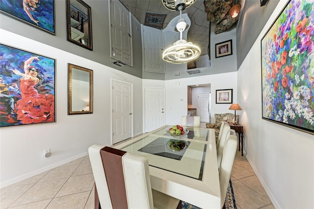 dining room with a towering ceiling and light tile patterned floors