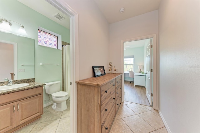 bathroom featuring vanity, toilet, and tile patterned flooring