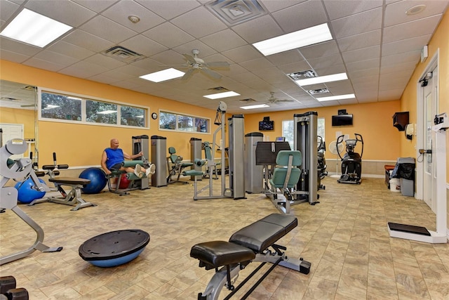 gym featuring a drop ceiling and ceiling fan