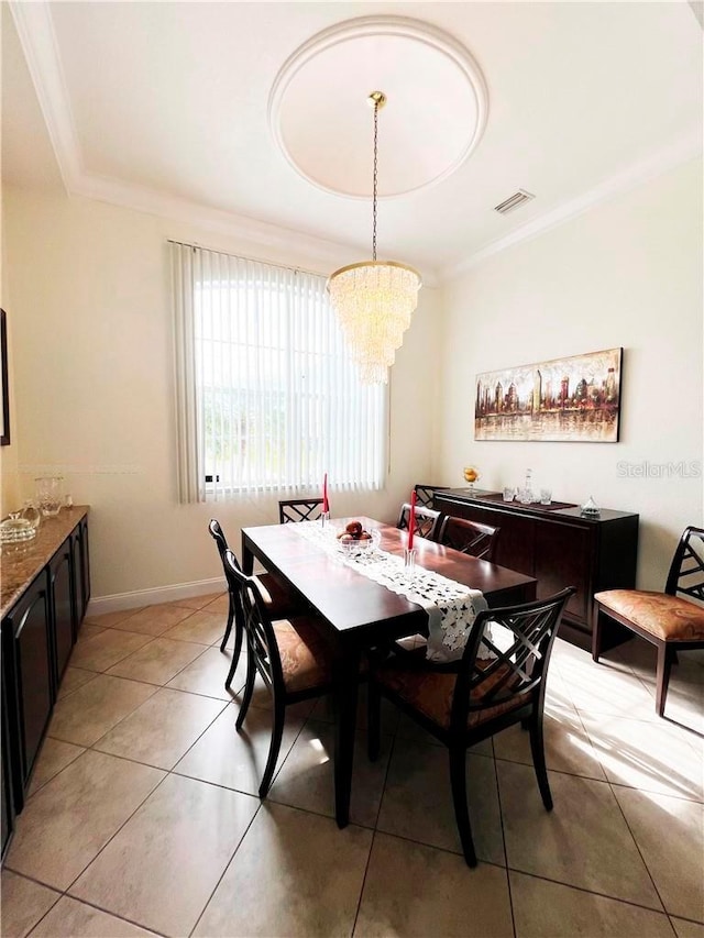 dining space featuring light tile patterned floors, ornamental molding, and a chandelier