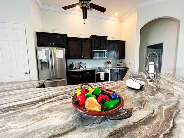 kitchen featuring tasteful backsplash, ceiling fan, sink, stainless steel appliances, and ornamental molding