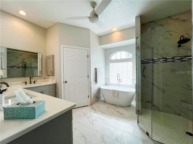 bathroom featuring ceiling fan, separate shower and tub, and vanity