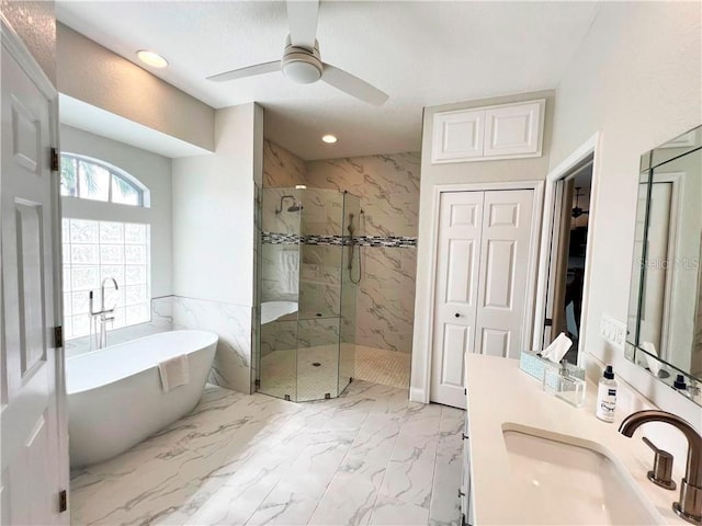 bathroom with ceiling fan, separate shower and tub, and vanity