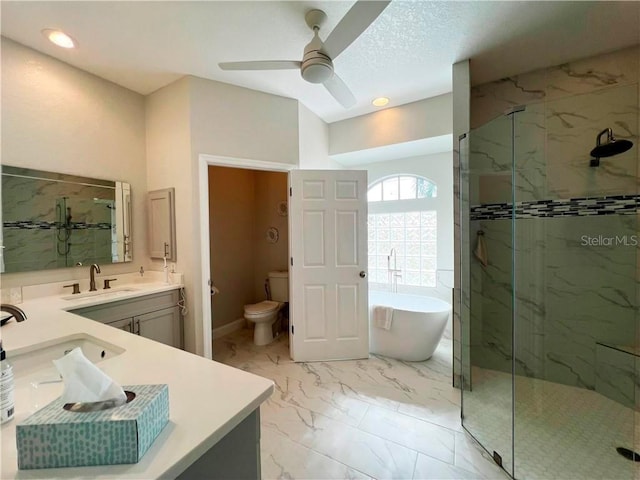 full bathroom with toilet, vanity, ceiling fan, a textured ceiling, and shower with separate bathtub