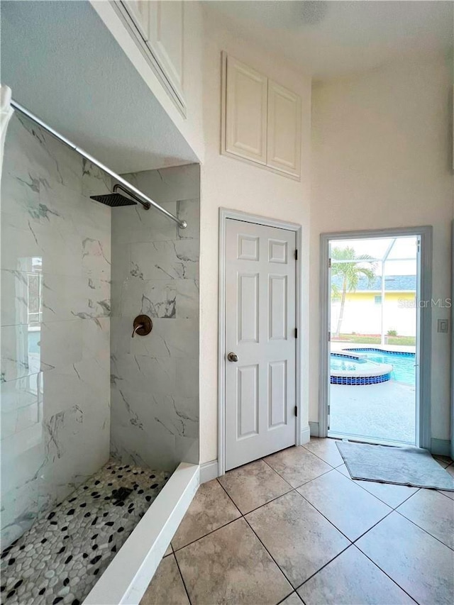 bathroom featuring tile patterned floors and a tile shower