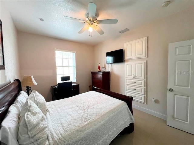 bedroom with ceiling fan and a textured ceiling