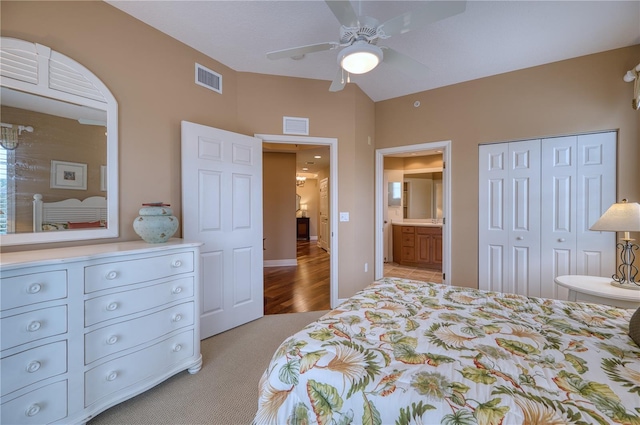 bedroom with ceiling fan, ensuite bath, a closet, and light carpet