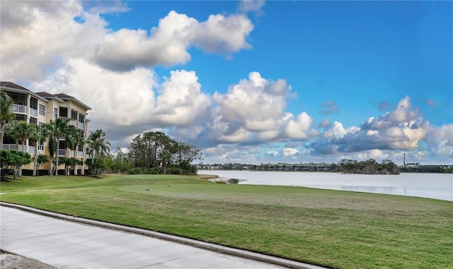 view of community with a yard and a water view