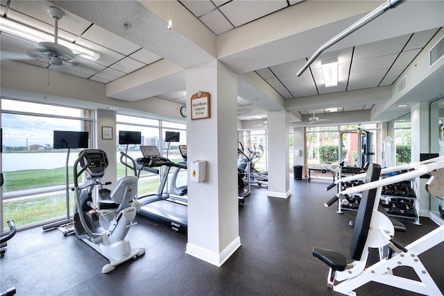 gym featuring ceiling fan and a drop ceiling