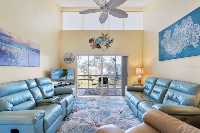 living room with ceiling fan and a high ceiling