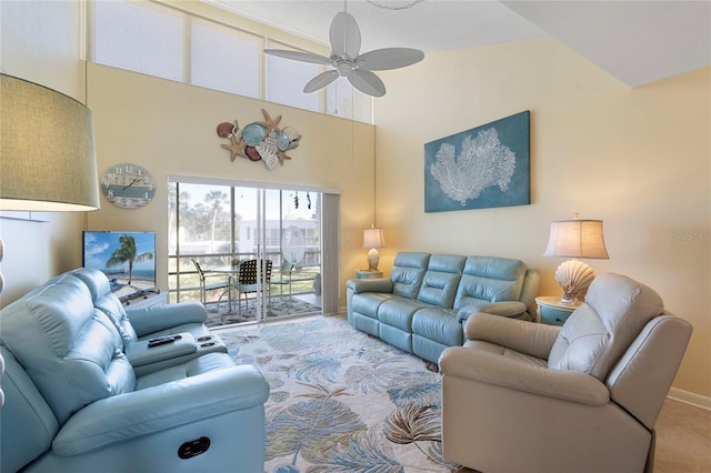 living room featuring a towering ceiling, ceiling fan, and carpet flooring