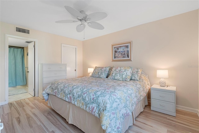 bedroom with connected bathroom, ceiling fan, and light hardwood / wood-style flooring